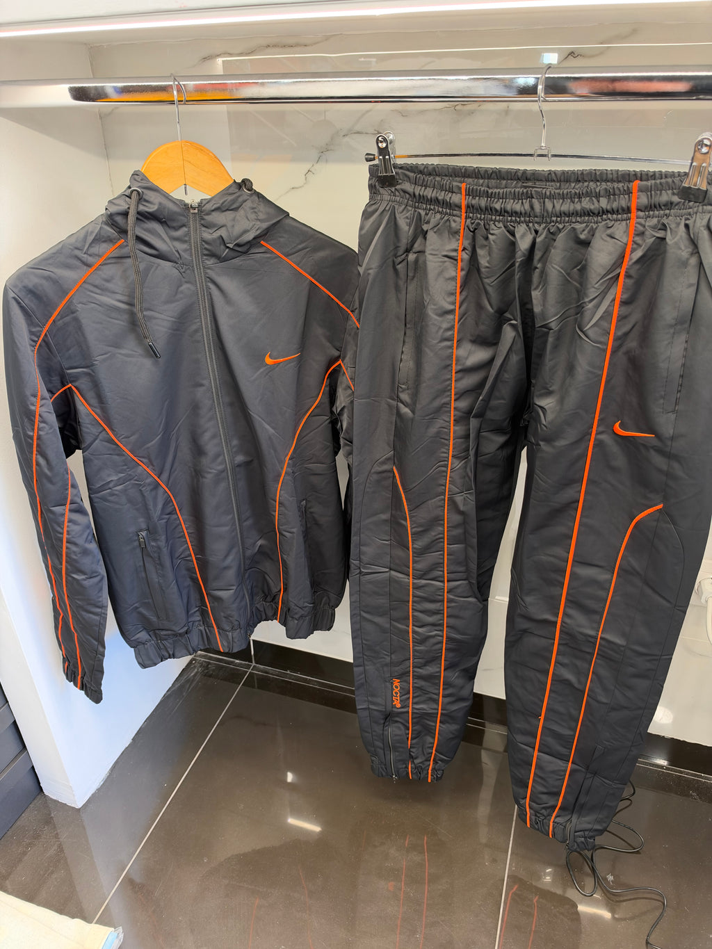 Nike NOCTA Windbreaker Tracksuit – Σετ Αντιανεμικής Φόρμας Μαύρο/Πορτοκαλί